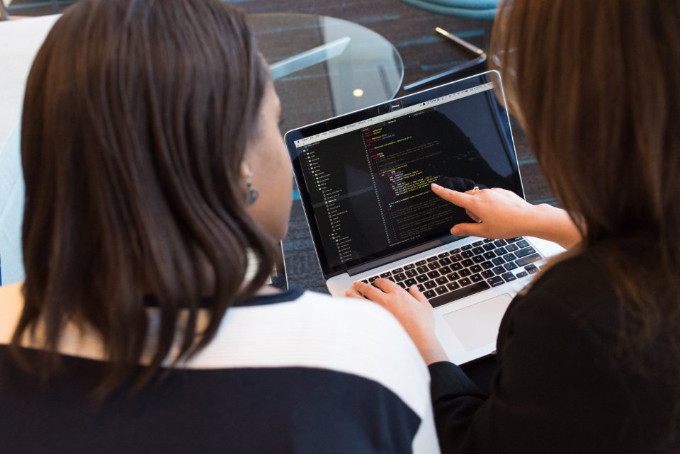 Software developers discussing a project together at a laptop